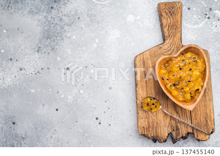 Mango and passion fruit jam in heart shaped wooden bowl, tropical sweet spread with seeds on rustic background Mango and passion fruit jam in heart shaped wooden bowl, tropical sweet spread with seeds on rustic background 137455140