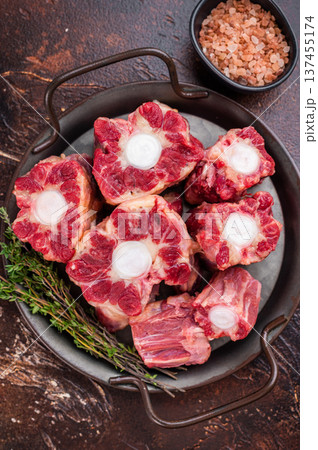 Raw Oxtail pieces in pan with fresh thyme, top view rustic food scene showing collagen rich beef for stock 137455174
