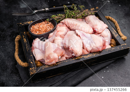 Beautifully arranged raw chicken wings, ready to soak up your favorite marinades for a tasty culinary adventure. black background. top view 137455266