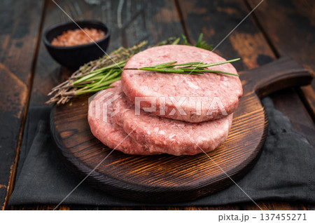 Uncooked beef and pork meat patty on a wooden board, inviting you to create your favorite gourmet burger recipes. wooden background. top view 137455271