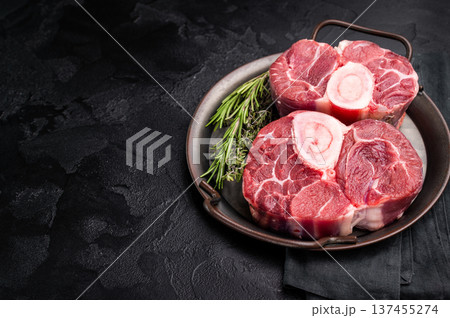 Freshly cross cut shank osso buco, ossobuco meat featuring succulent meat and bone marrow, waiting to elevate your cooking experience. black background. top view 137455274