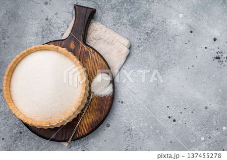 Versatile white sugar in a rustic bowl, ready to enhance desserts and beverages with its delightful sweetness. grey background. top view Versatile white sugar in a rustic bowl, ready to enhance desserts and beverages with its delightful sweetness. grey background. top view 137455278