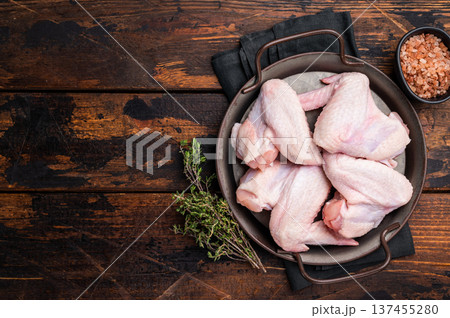 Pristine raw poultry wings, waiting to be seasoned and transformed into mouthwatering dishes for any occasion. wooden background. top view 137455280