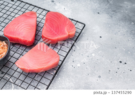 Premium raw tuna fillet steak, ideal for grilling or sashimi, a must-have for gourmet dishes and healthy meals. grey background. top view 137455290
