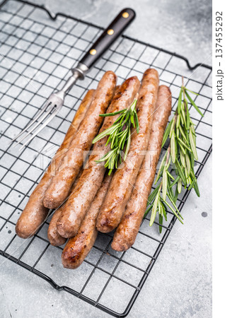 Flavorful grilled sausage links on a rack, inviting you to enjoy a hearty meal with family and friends. grey background. top view Flavorful grilled sausage links on a rack, inviting you to enjoy a hearty meal with family and friends. grey background. top view 137455292