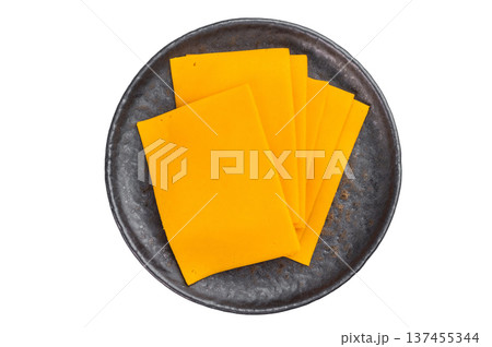 Sliced cheddar style cheese on metal plate top view over isolated background with copy space dairy ingredient for cooking 137455344