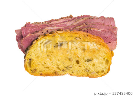 Gourmet pastrami brisket sandwich made from thin sliced cured deli meat and seed crusted bread on a bright white studio background. 137455400