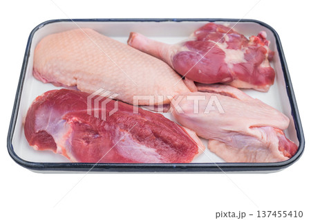 Fresh uncooked duck assortment including breast wing and leg displayed in white enamel pan perfect for culinary preparation visuals. Fresh uncooked duck assortment including breast wing and leg displayed in white enamel pan perfect for culinary preparation visuals. 137455410