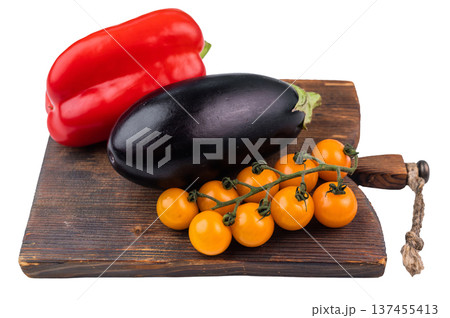 Fresh vegetables on wooden cutting board isolated on white background, red bell pepper eggplant and yellow cherry tomatoes Fresh vegetables on wooden cutting board isolated on white background, red bell pepper eggplant and yellow cherry tomatoes 137455413