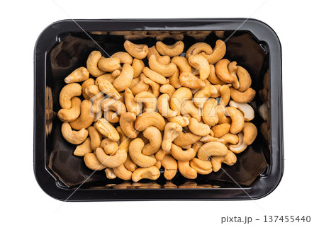 Cashew nuts packed in a black plastic container on a bright white background creating a clean ingredient 137455440
