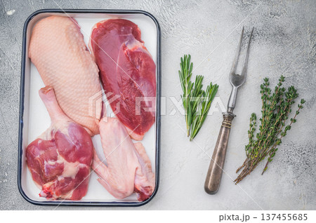 Duck meat selection including breast wing and thigh in enamel tray on light background great for recipe content food styling and stock use. Duck meat selection including breast wing and thigh in enamel tray on light background great for recipe content food styling and stock use. 137455685