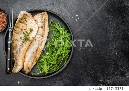 Pan fried pike perch fillet served with fresh arugula in plate, healthy freshwater fish meal. Pan fried pike perch fillet served with fresh arugula in plate, healthy freshwater fish meal. 137455714
