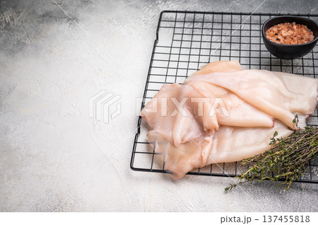 Close up of tender raw squid showcasing its smooth texture, ideal for culinary creativity and seafood lovers. grey background. top view 137455818