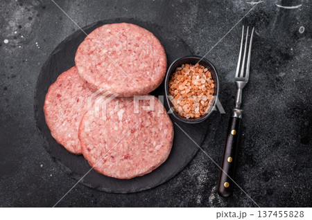 Fresh raw beef meat patty ready for grilling, perfect for homemade burgers and delicious family meals.black background. top view Fresh raw beef meat patty ready for grilling, perfect for homemade burgers and delicious family meals.black background. top view 137455828