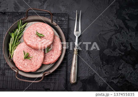 Freshly formed raw meat patty with herbs for burgers, perfect for grilling or frying to satisfy your cravings. black background. top view Freshly formed raw meat patty with herbs for burgers, perfect for grilling or frying to satisfy your cravings. black background. top view 137455835