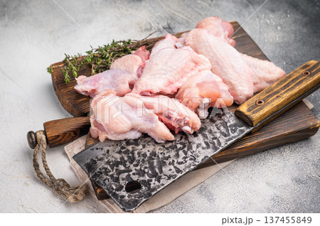 Fresh chicken wings, showcasing their natural texture, perfect for creating savory snacks or hearty meals. white background. top view 137455849