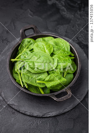 Crisp and lush fresh spinach ready for your favorite recipes, a versatile superfood for every meal. black background. top view Crisp and lush fresh spinach ready for your favorite recipes, a versatile superfood for every meal. black background. top view 137455856