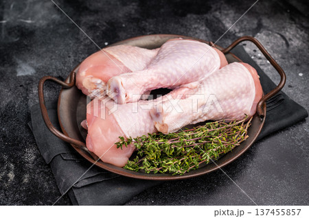 Freshly cut drumsticks, raw chicken legs featuring smooth skin and succulent meat, perfect for a hearty family meal. black background. top view Freshly cut drumsticks, raw chicken legs featuring smooth skin and succulent meat, perfect for a hearty family meal. black background. top view 137455857
