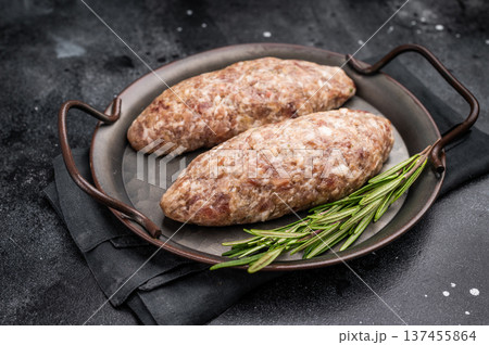 Freshly prepared raw Kofta kebab, marinated with spices, ready for grilling and bursting with flavor. black background. top view Freshly prepared raw Kofta kebab, marinated with spices, ready for grilling and bursting with flavor. black background. top view 137455864
