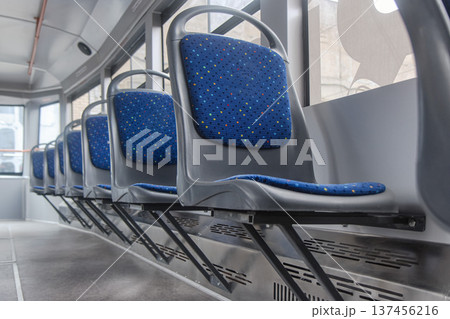 Row of blue passenger seats inside a modern tram 137456216