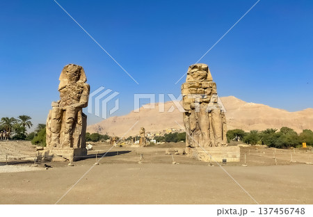 Colossi of Memnon, two massive stone statues representing the pharaoh, Luxor, Egypt 137456748