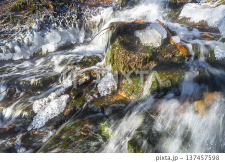 Winter waterfall with frozen ice formations and flowing water 137457598