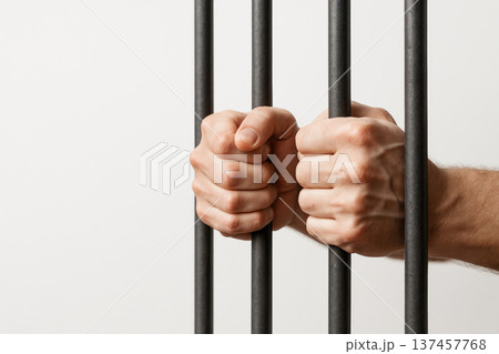 Hands behind prison bars as a symbol of unfreedom. Space for text. Hands behind prison bars as a symbol of unfreedom. Space for text. 137457768