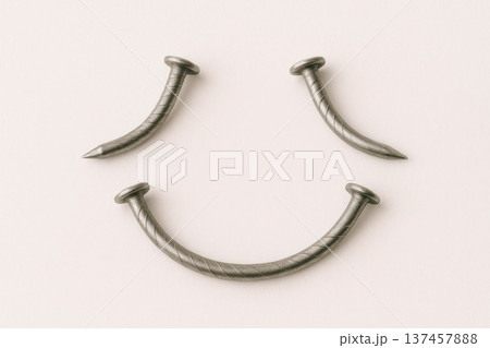 Nails bent in the shape of a smiling face. 137457888