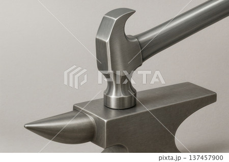 A metal hammer connected to an anvil in a monolithic form. Space for text. A metal hammer connected to an anvil in a monolithic form. Space for text. 137457900
