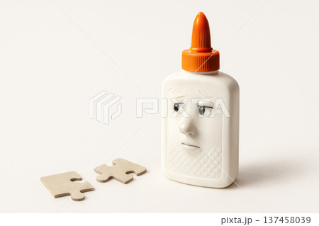 Glue with a sad face next to the puzzle pieces. Space for text. 137458039