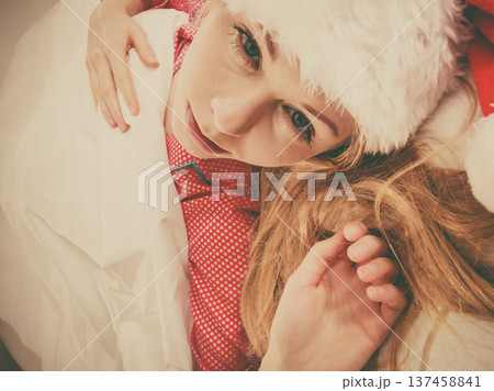 Happy woman wearing pajamas and Santa Claus hat Happy woman wearing pajamas and Santa Claus hat 137458841