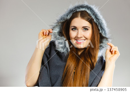 Happy woman wearing dark poncho with hood 137458905