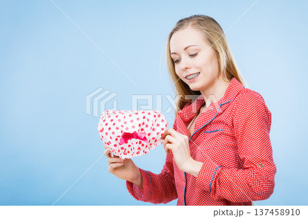 Young woman wearing pink pajamas putting bathing cap Young woman wearing pink pajamas putting bathing cap 137458910