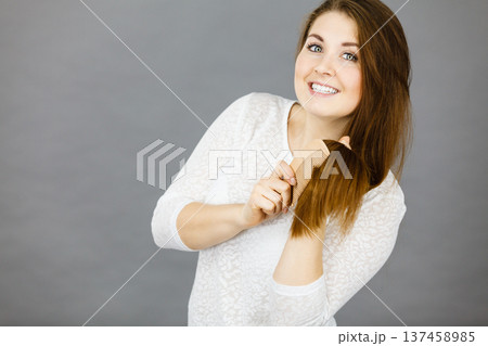 Happy woman brushing her hair Happy woman brushing her hair 137458985