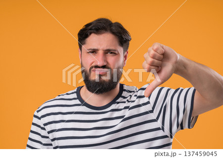 Portrait of unhappy man condemns with sign of dislike. Young millennial guy  137459045