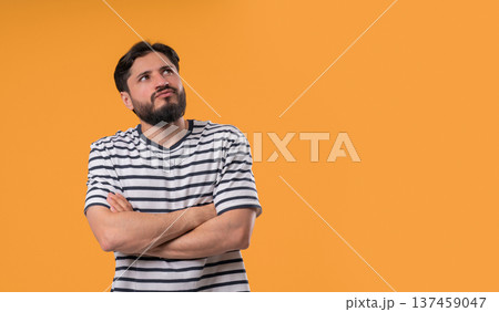 Thinking man looking up, searching opportunity on yellow background. Curious pensive man considering Thinking man looking up, searching opportunity on yellow background. Curious pensive man considering 137459047