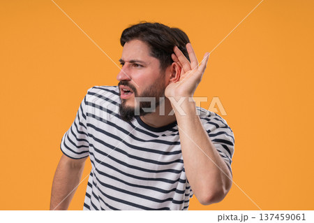 Mature Man Pointing To Ear With Confused Face, Signaling He Cant Hear Clearly 137459061