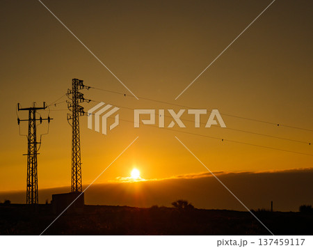 High voltage towers on coast at sunset 137459117
