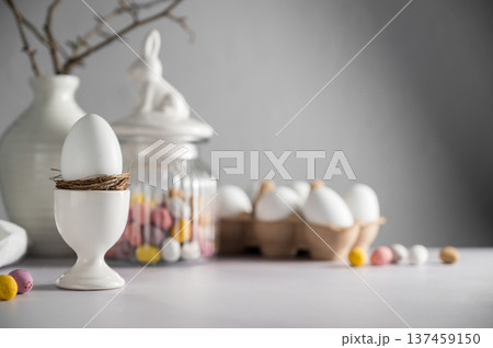 Easter background, table with spring decorations: eggs, candies, twigs in a vase and egg candies.  137459150