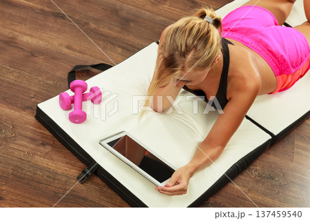 Fit woman lying on floor with tablet pc Fit woman lying on floor with tablet pc 137459540