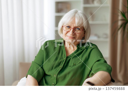 Portrait of beautiful senior woman relaxing on sofa at home Portrait of beautiful senior woman relaxing on sofa at home 137459888