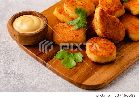 Fried crispy chicken nuggets on a wooden serving board. Fried crispy chicken nuggets on a wooden serving board. 137460088
