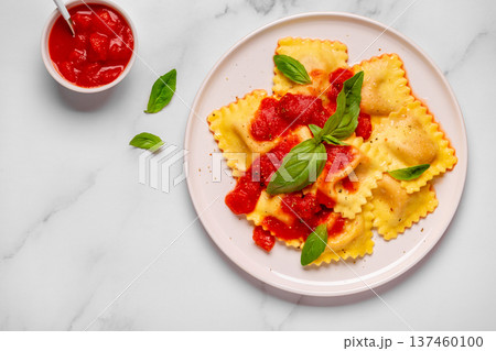 Delicious appetizing ravioli with tomato sauce and basil Delicious appetizing ravioli with tomato sauce and basil 137460100