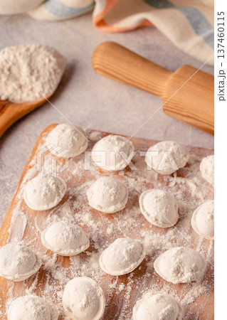 Homemade raw dumplings on the board. Homemade raw dumplings on the board. 137460115