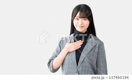 胸に手を当てて立つ女性・ビジネスウーマン 胸に手を当てて立つ女性・ビジネスウーマン 137460194
