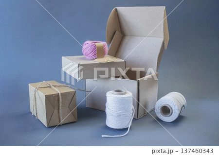 Cardboard boxes and packing twine, delivery concept. Stacking of postal cardboard boxes and packing twine. 137460343
