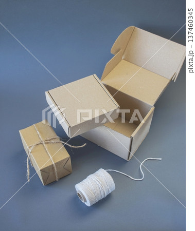 Cardboard boxes and packing twine, delivery concept. Stacking of postal cardboard boxes and packing twine. 137460345