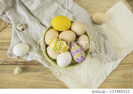 Easter, preparation for the holiday. Various colored and fresh chicken and quail eggs on a rustic wooden table. Easter, preparation for the holiday. Various colored and fresh chicken and quail eggs on a rustic wooden table. 137460352