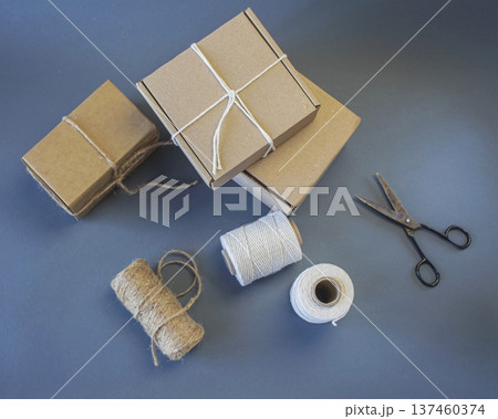 Cardboard boxes and packing twine, delivery concept. Stacking of postal cardboard boxes and packing twine. 137460374