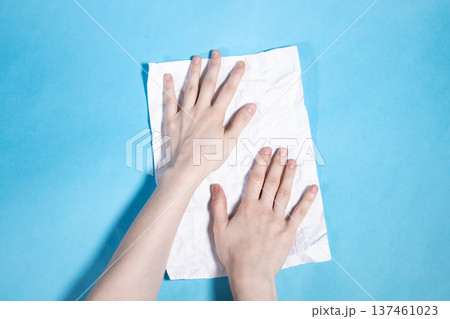 above view of two hands flating sheet of paper above view of two hands flating sheet of paper 137461023